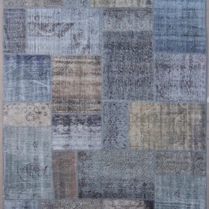 May include: A patchwork rug with a variety of blue, brown, and beige colors. The rug is made of different pieces of fabric sewn together to create a unique design.