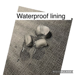 K&ouml;nnte beinhalten: Nahaufnahme einer grauen Stoffoberfl&auml;che mit dem Aufdruck "Waterproof lining". Vier Eisw&uuml;rfel liegen auf dem Stoff, mit sichtbaren Wassertropfen um sie herum.