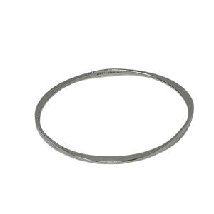 May include: A silver-colored bangle bracelet. The bracelet is a simple, thin band with a slightly flattened profile. The text "AVERY STERLING" is stamped on the inside of the bracelet. The bracelet is a minimalist design.