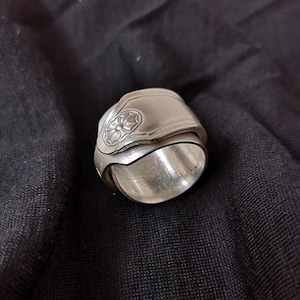 May include: A silver ring made from a repurposed spoon with a floral design.