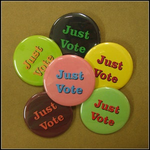 May include: Six round buttons with the text "Just Vote" in different colours and fonts. The buttons are green, yellow, pink, brown, black, and green.