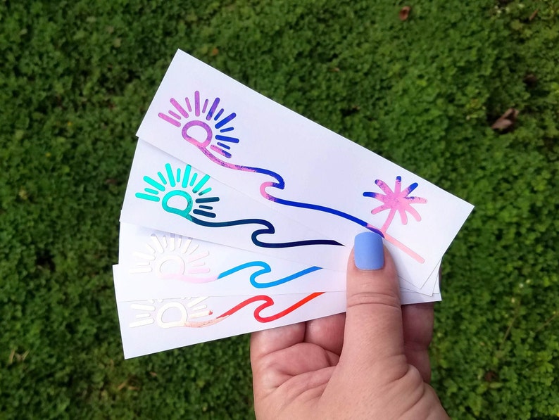 Puede incluir: Cuatro pegatinas de vinilo de diferentes colores con un dise&ntilde;o de sol, ola y palmera. Las pegatinas est&aacute;n sobre un fondo blanco.