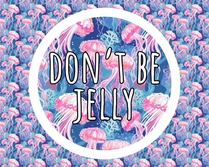 May include: A circular graphic featuring a repeating pattern of pink jellyfish on a dark blue background. Centered within the white-bordered circle is the text DON'T BE JELLY in a bold, black-outlined white font against the jellyfish pattern.