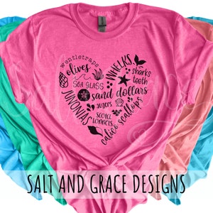 May include: Pink t-shirt with a black heart design featuring the text "wentletraps olives sea glass JUNONIAS whelks sharks teeth sand dollars augers scotch lonnets calico scallops". The text is arranged in a heart shape. The shirt has the text "SALT AND GRACE DESIGNS" at the bottom.