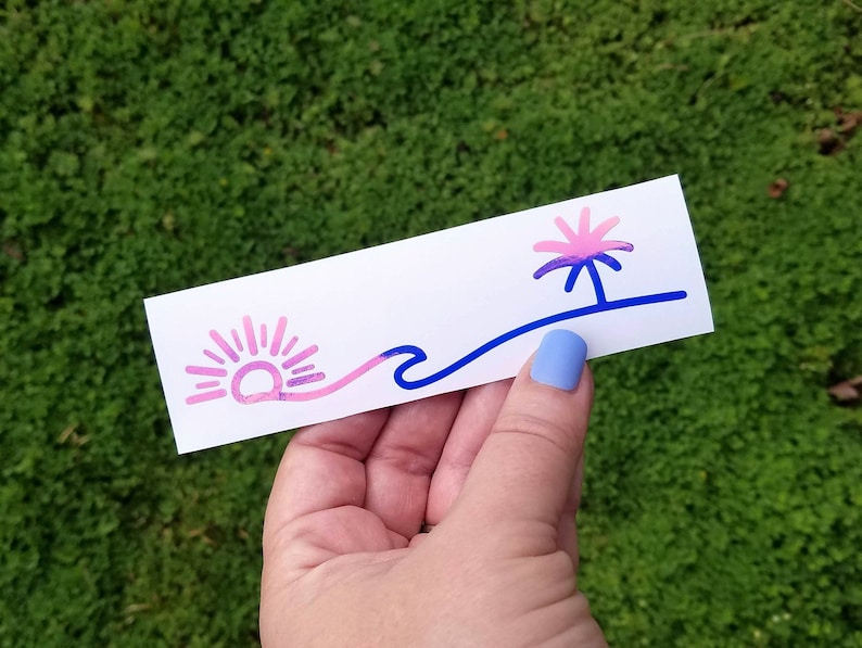 Puede incluir: Una pegatina con un dise&ntilde;o de puesta de sol rosa y azul, una ola y una palmera. La pegatina est&aacute; sobre un fondo blanco.