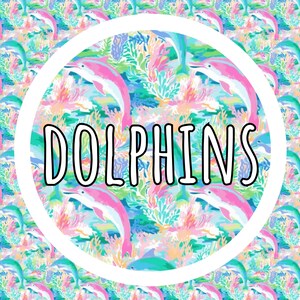 May include: A repeating pattern featuring pink dolphins swimming among colorful coral reefs and aquatic plants. Centered in the image is a large white circle containing the word DOLPHINS in bold, black, outlined capital letters.