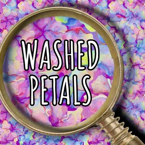 May include: A magnifying glass with a gold-colored frame is centered over a floral pattern. The text "WASHED PETALS" is in white, outlined in black. The background features a watercolor-style design in shades of purple, blue, and pink.