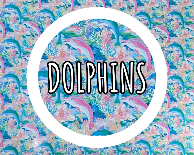 May include: A colorful pattern featuring dolphins in shades of blue and pink, with coral and aquatic plants. The word "DOLPHINS" is displayed in a white circle. The design is vibrant and suitable for various applications.