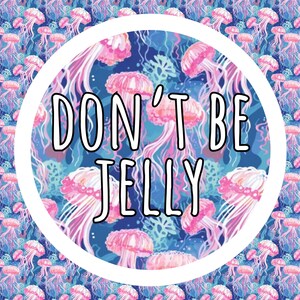 K&ouml;nnte beinhalten: Ein kreisf&ouml;rmiges Design mit dem Text "DON'T BE JELLY" in Wei&szlig;, vor einem Hintergrund aus rosa Quallen auf einem blau-violetten Muster. Geeignet f&uuml;r verschiedene Produkte.