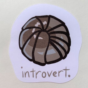 May include: A white sticker with a brown and gray illustration of a curled up snail. The text "introvert." is written below the snail.