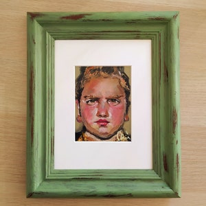 Oil portrait painting of a blonde girl with green eyes and plump cheeks and a pink face. Original and unique, framed.