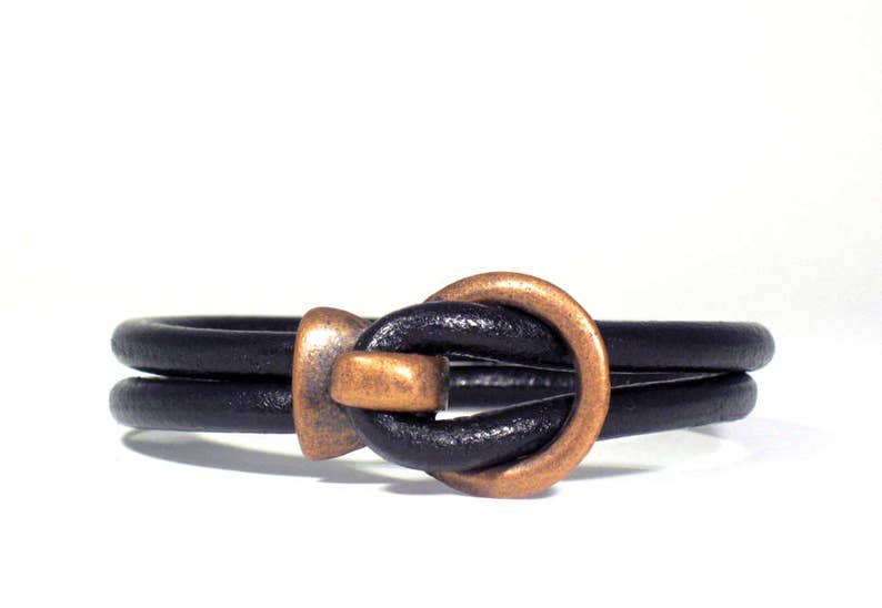 Men's bracelet made of 5 mm. black leather cord and cooper color closure.