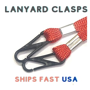 May include: Two black plastic lanyard clasps attached to red and silver lanyards.  SHIPS FAST USA.