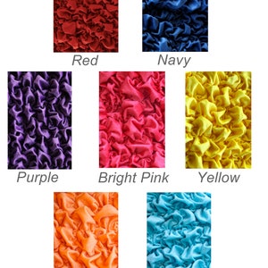 May include: A collection of fabric swatches in various colors, including red, navy, purple, bright pink, yellow, orange, and bright light blue. The fabric has a crinkled texture.