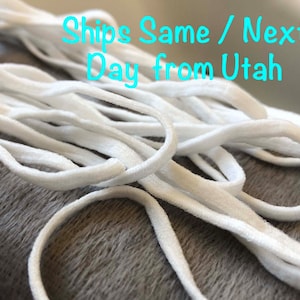 May include: White elastic cord, a type of string used for crafts and sewing projects. The cord is coiled and arranged in a pile. The text "Ships Same / Next Day from Utah" is visible in the image.
