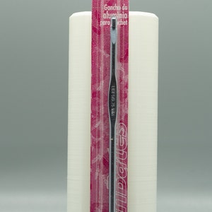 May include: A silver aluminum crochet hook with a pink and white label. The label reads "Susan Bates Aluminum Crochet Hook" and includes the size 3.75 mm, F5, US.