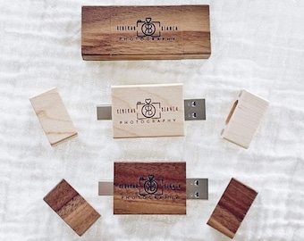 May include: Three wooden USB flash drives with a custom engraved logo that reads "Rebekah & Bianca Photography" with a camera icon and the initials "RB". The flash drives are in different stages of being opened, with one closed, one partially open, and one fully open.