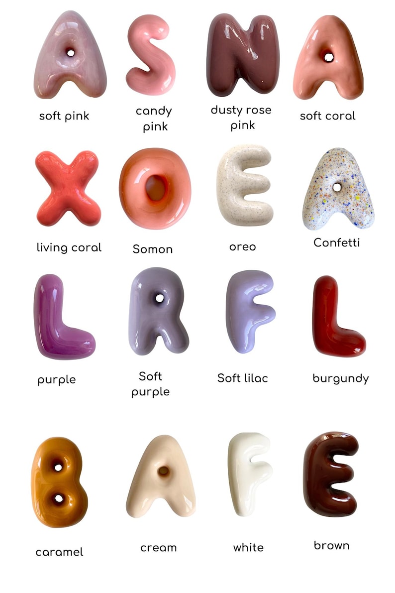 May include: A selection of glossy letter sculptures in a range of colours, such as soft pink, candy pink, dusty rose, and soft coral. Each letter has a unique design and is labelled with its colour name. The letters are arranged in a grid.