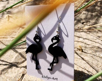 May include: A pair of black flamingo-shaped dangle earrings with silver-toned metal hooks, displayed on a white rectangular card featuring the text Eivlys-Art printed in black at the bottom center of the card.