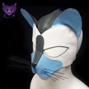 May include: A white leather cat mask with blue ears and a gray leather baseball cap. The mask has black stitching and a black nose with whiskers.