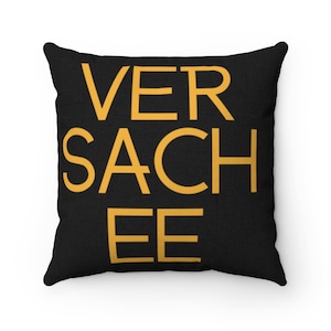 May include: Black throw pillow with the text "VER SACHEE EE" in yellow.