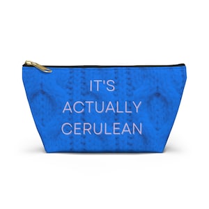 May include: A blue zippered pouch with the text "It's Actually Cerulean" in a light purple color.
