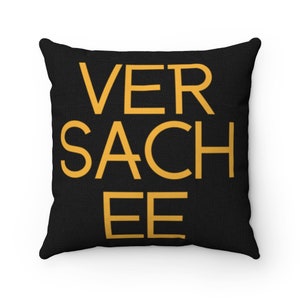 May include: Black throw pillow with the text "VER SACHEE EE" in yellow.