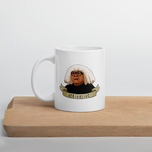 May include: White ceramic mug featuring a cartoon image of a person with a white wig and glasses. The image is accompanied by a banner that reads "derivative".