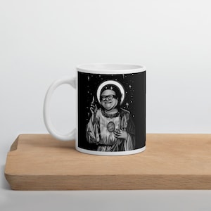 Może przedstawiać: Biały kubek ceramiczny z czarno-białym obrazkiem mężczyzny z aureolą i sercem z napisem "Treat Yo Self". Tło jest czarne z białymi gwiazdami.