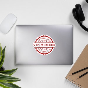 May include: Red and white round sticker with the text "The Dobby Club VIP Member Est. Corfu '06" in a white circle with five red stars.