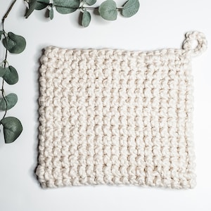 Può includere: Un sottopentola in crochet bianco con un manico ad anello. Il sottopentola è realizzato con un semplice motivo a punto ed è perfetto per proteggere le mani dai piatti caldi.