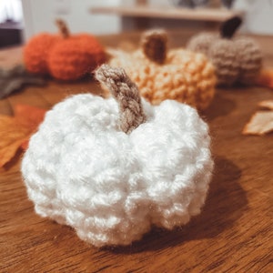 Crochet Mini Pumpkins in various colors, closeup of white.