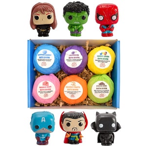 May include: A set of six bath bombs in a blue box with a variety of colours and scents. The bath bombs are decorated with labels that say "Cotton Candy Bath Bomb", "Lavender Bath Bomb", "Candy Crush Bath Bomb", "Bubble Gum Bath Bomb", "Monkey Farts Bath Bomb", and "Cocoa Kiss Bath Bomb". The box also includes six small figurines of popular superhero characters.