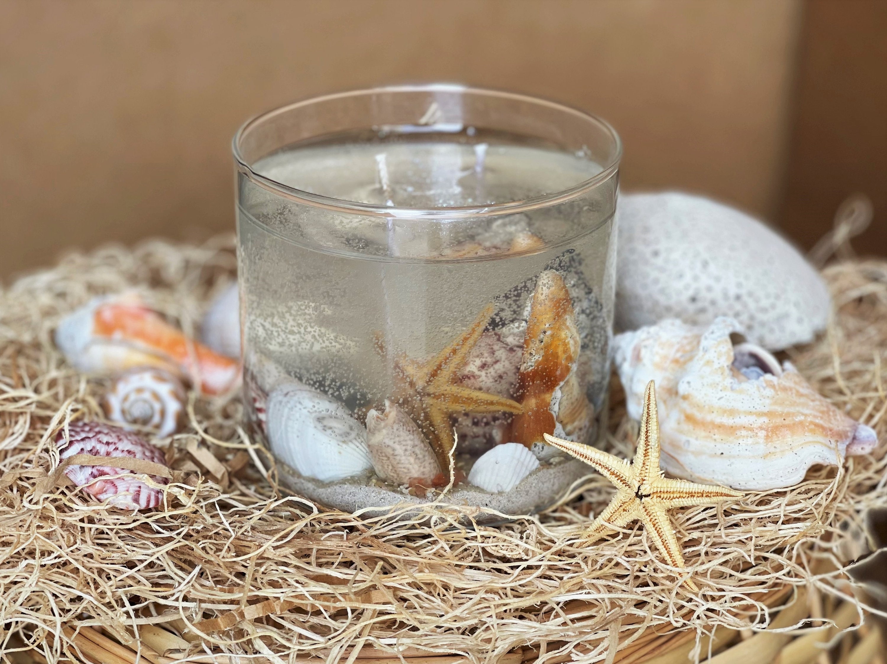 Create your own Gel candle. First decorate the bottom of the container with  colored sand, shells, glass…