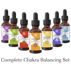 May include: A set of six amber glass bottles with black droppers, each labeled with a different chakra name and color. The labels include "Crown," "Heart," "Root," "Sacral," "Solar Plexus," and "Third Eye." The text "Complete Chakra Balancing Set" is at the bottom.