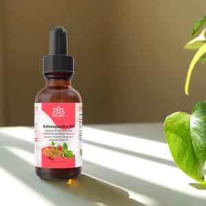 May include: A brown glass bottle with a dropper top, labeled "Relaxcation Ashwagandha Oil". The label is white with pink accents and features a small illustration of a flower. The bottle is sitting on a white surface.