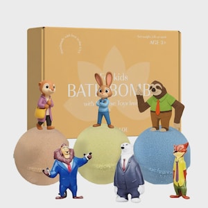 May include: A set of children's bath bombs with surprise toys. The tan box has text and a floral design. Six character figurines, including a rabbit, sloth, and fox, stand on top of the bath bombs. The bath bombs are in various colours.