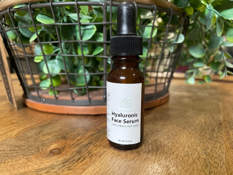 May include: A brown glass bottle with a black dropper top and a white label that reads "Hyaluronic Face Serum with organic rose water". The bottle contains 1.5 fl oz (45 ml) of serum.