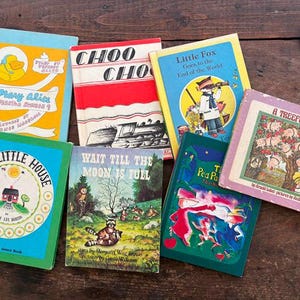 May include: A collection of vintage children's books with colorful covers. Titles include "Mary Alice," "Choo Choo," "Little Fox," "The Little House," "Wait Till the Moon is Full," "Tea Party," and "A Treeful of Pigs." The books are arranged on a wooden surface.