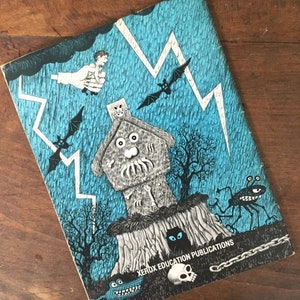 Pode incluir: Uma capa de livro vintage com uma ilustra&ccedil;&atilde;o azul e preta de uma casa assombrada, morcegos, raios e uma caveira. O texto "Xerox Education Publications" est&aacute; impresso na parte inferior da capa.