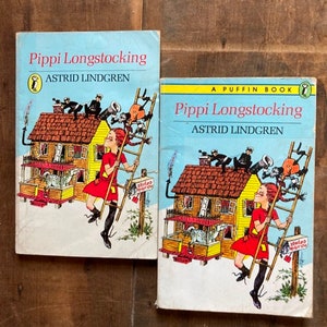 May include: Two vintage paperback books with colorful illustrations of Pippi Longstocking, a fictional character created by Astrid Lindgren. The books are titled "Pippi Longstocking" and "A Puffin Book Pippi Longstocking".