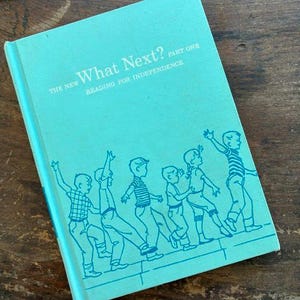 May include: A vintage book titled "What Next?" in a light teal color. The cover features a line drawing of children walking, with the text "Reading for Independence." The book is part one of a series.