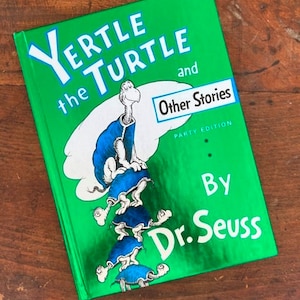 May include: A green book with the title "Yertle the Turtle and Other Stories" by Dr. Seuss. The cover features an illustration of a stack of turtles with the largest turtle on top.