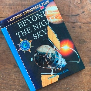May include: A blue book titled "Beyond the Night Sky" with the words "Ladybird Explorers Plus" on the cover. The book features a colorful image of a space shuttle and a planet.