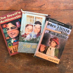 May include: Three paperback books with colorful covers. The Devil's Arithmetic, Hide and Seek, and When Hitler Stole Pink Rabbit.