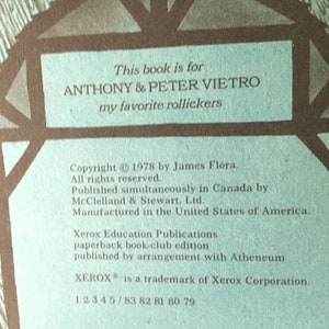 Pode incluir: Um livro azul e castanho com o texto "This book is for Anthony & Peter Vietro my favorite rollickers" na capa da frente. As informa&ccedil;&otilde;es de direitos autorais na contracapa dizem "Copyright &copy; 1978 by James Flora. All rights reserved. Published simultaneously in Canada by McClelland & Stewart, Ltd. Manufactured in the United States of America. Xerox Education Publications paperback book-club edition published by arrangement with Atheneum XEROX&reg; is a trademark of Xerox Corporation. 1 2 3 4 5 / 83 82 81 80 79"