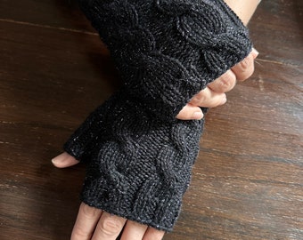 May include: Black fingerless gloves with a cable knit pattern and silver glitter thread.
