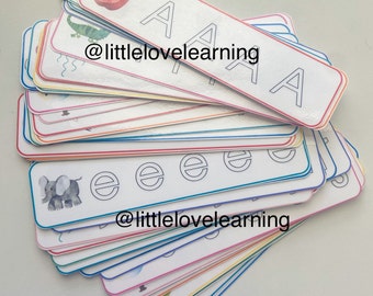Puede incluir: Una pila de tarjetas de memoria coloridas con diferentes letras del alfabeto e ilustraciones. Las tarjetas tienen un fondo blanco con contornos negros y el texto "@littlelovelearning" es visible en una de las tarjetas.