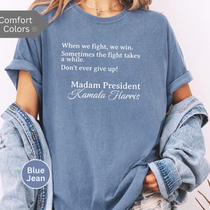 May include: A blue t-shirt with the text "When we fight, we win. Sometimes the fight takes a while. Don't ever give up! Madam President Kamala Harris" printed on the front.