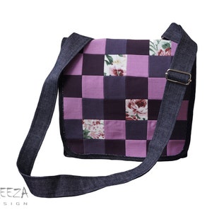 Könnte beinhalten: Eine violette und schwarze Patchwork-Messenger-Tasche mit einem Jeansriemen. Die Tasche hat auf einigen Quadraten ein Blumenmuster.